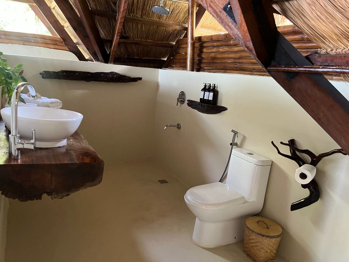 A bathroom with a toilet , sink and shower.