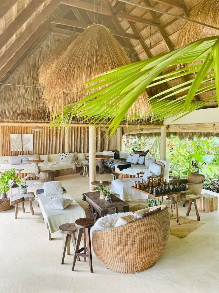 A large room with a lot of furniture and a thatched roof.