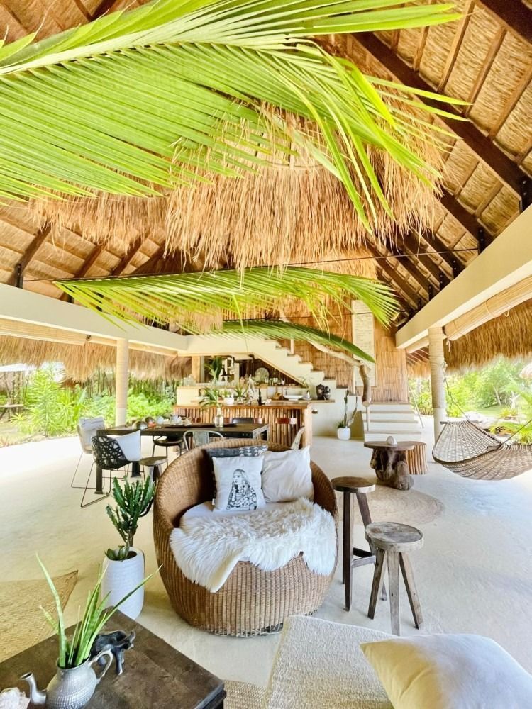 A living room filled with furniture and a thatched roof.