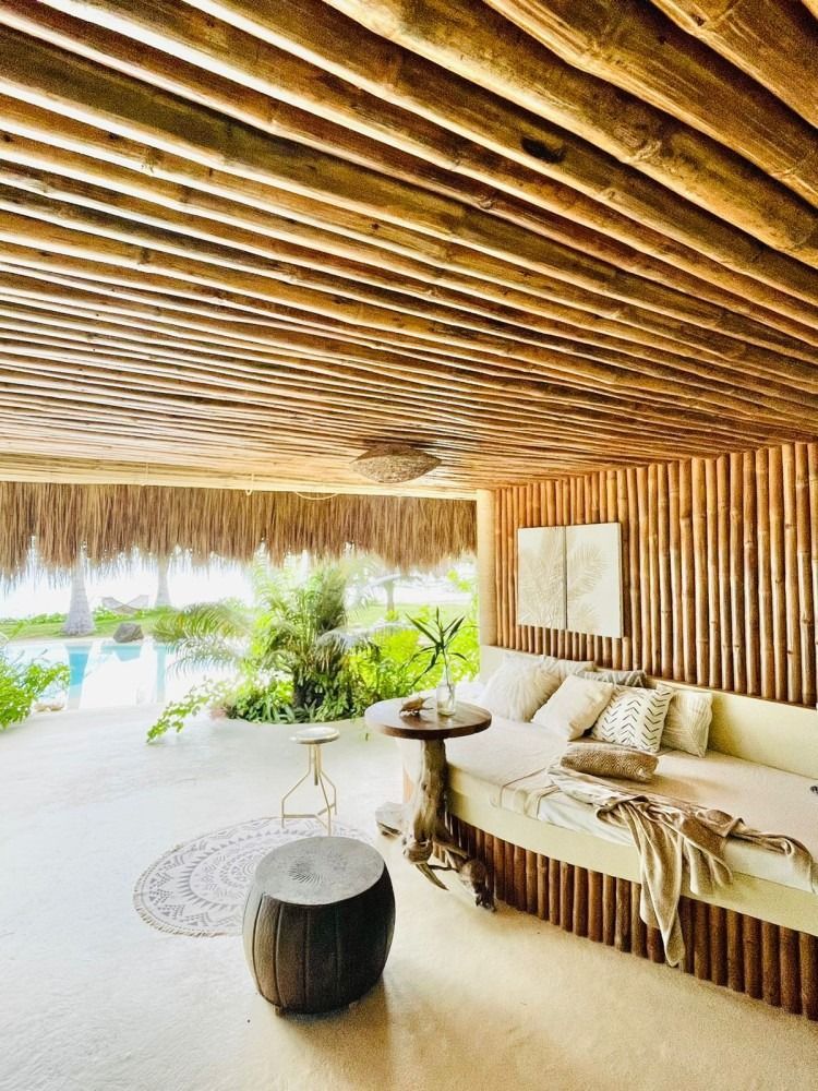 A living room with a couch , table , and thatched roof.