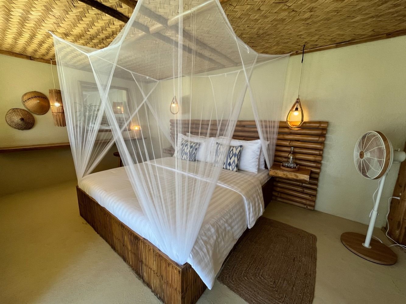A bedroom with a canopy bed and a fan.