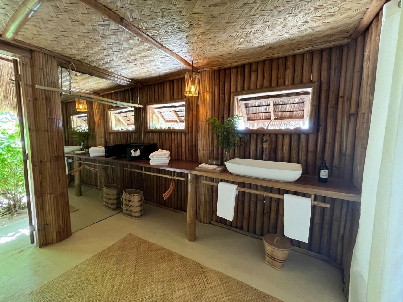 A bathroom with two sinks , a mirror and a wooden wall.