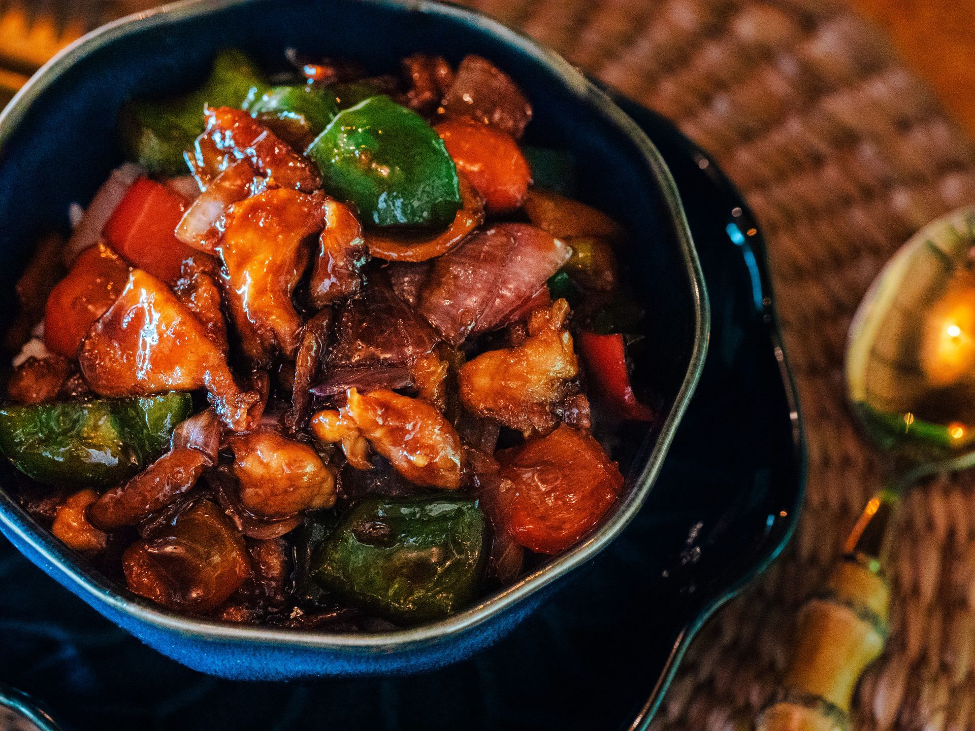A bowl of food with meat and vegetables on a table.