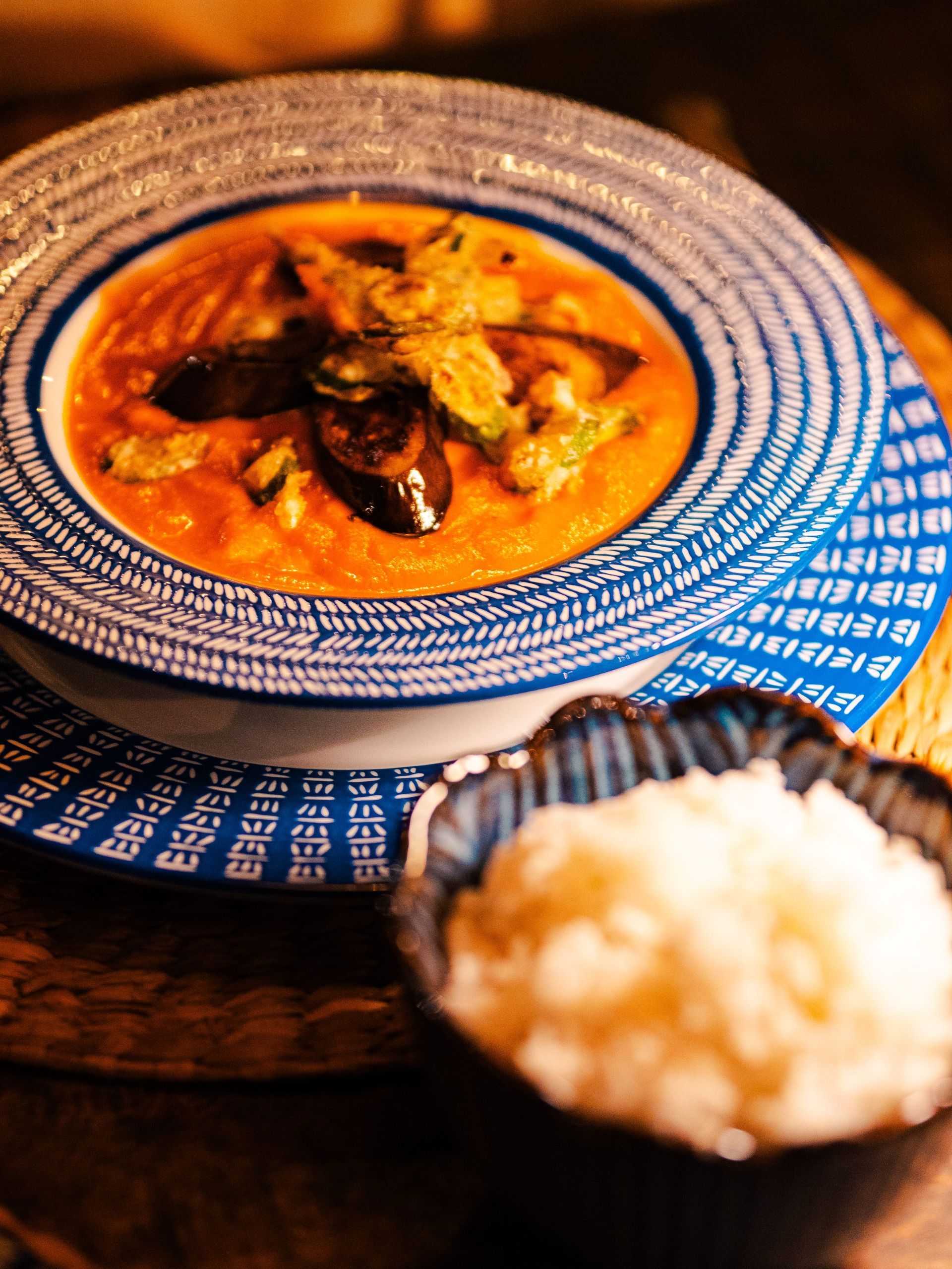 A bowl of soup next to a bowl of rice