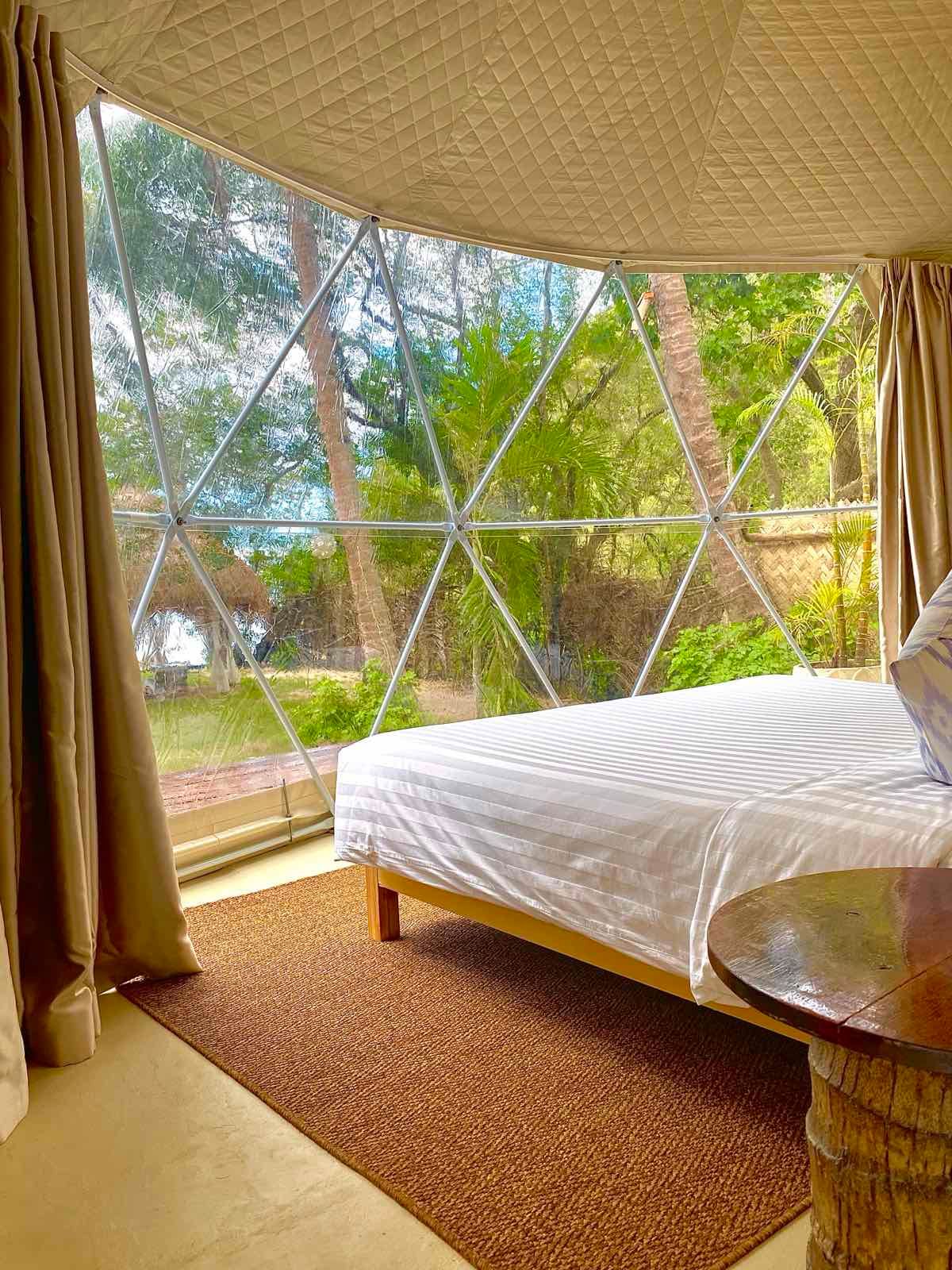 A bedroom with a bed and a table in a dome tent.