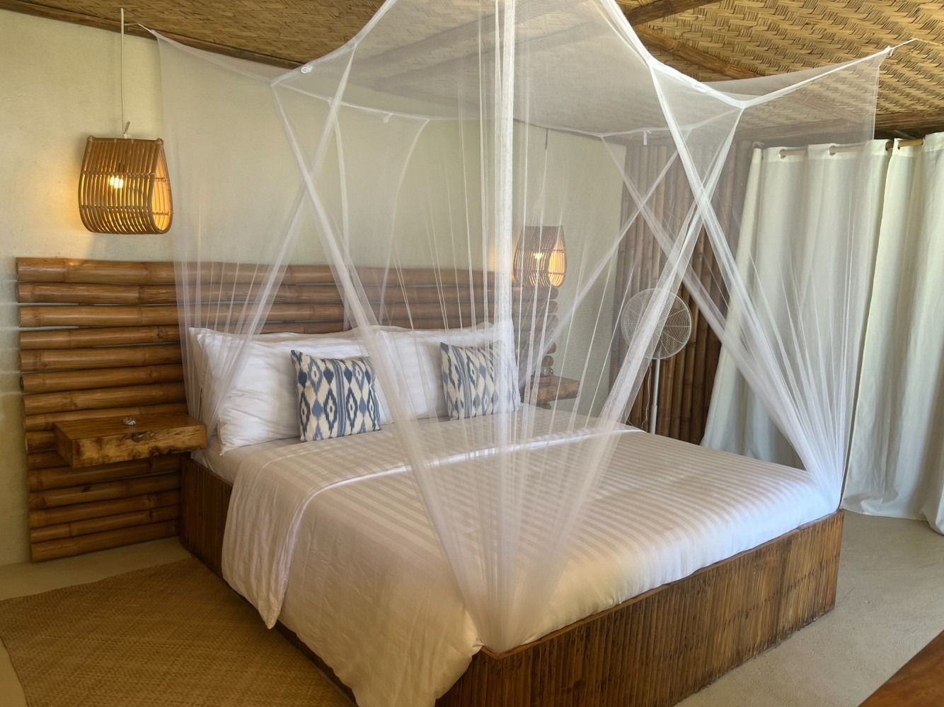 A bedroom with a canopy bed and a mosquito net.