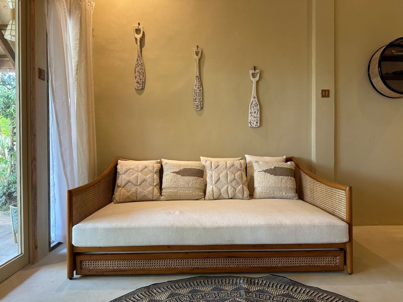 A couch is sitting in a living room next to a window.