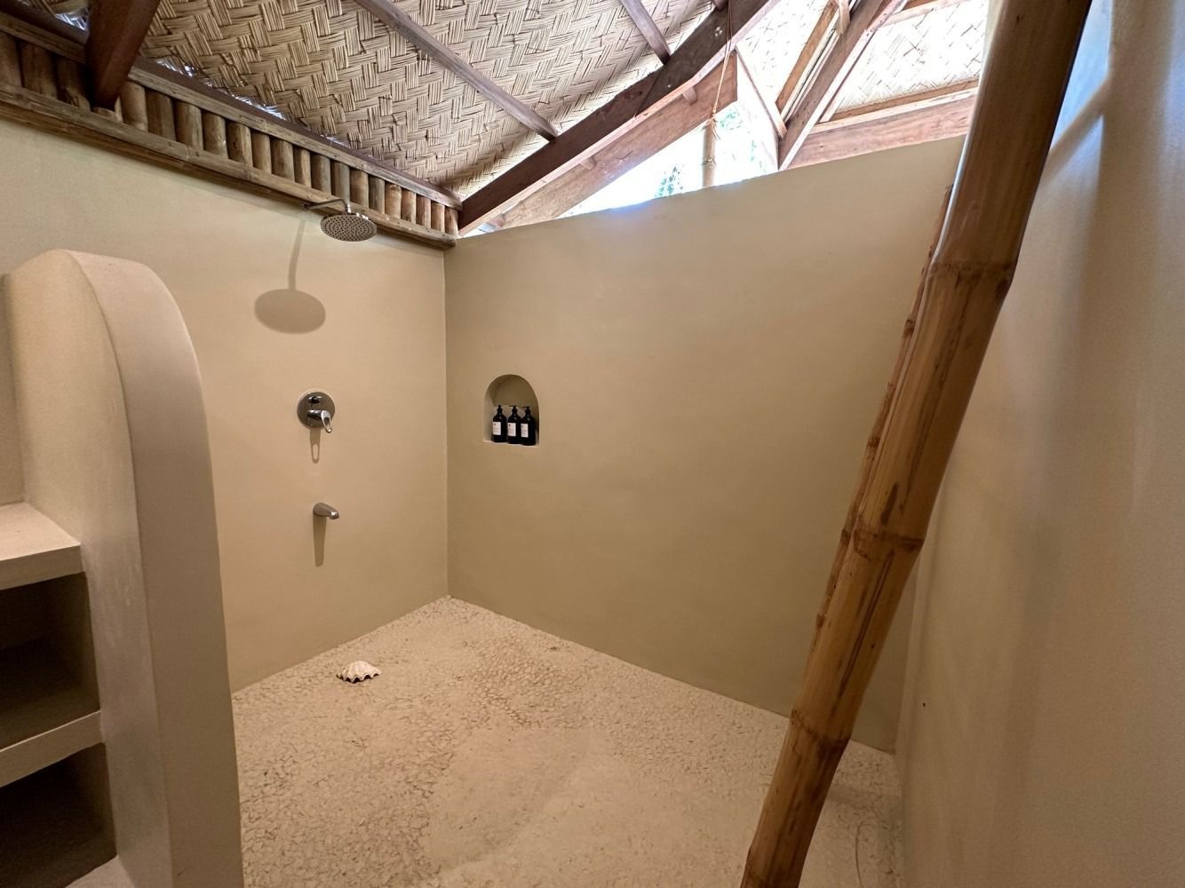 A bathroom with a shower and a bamboo ladder.