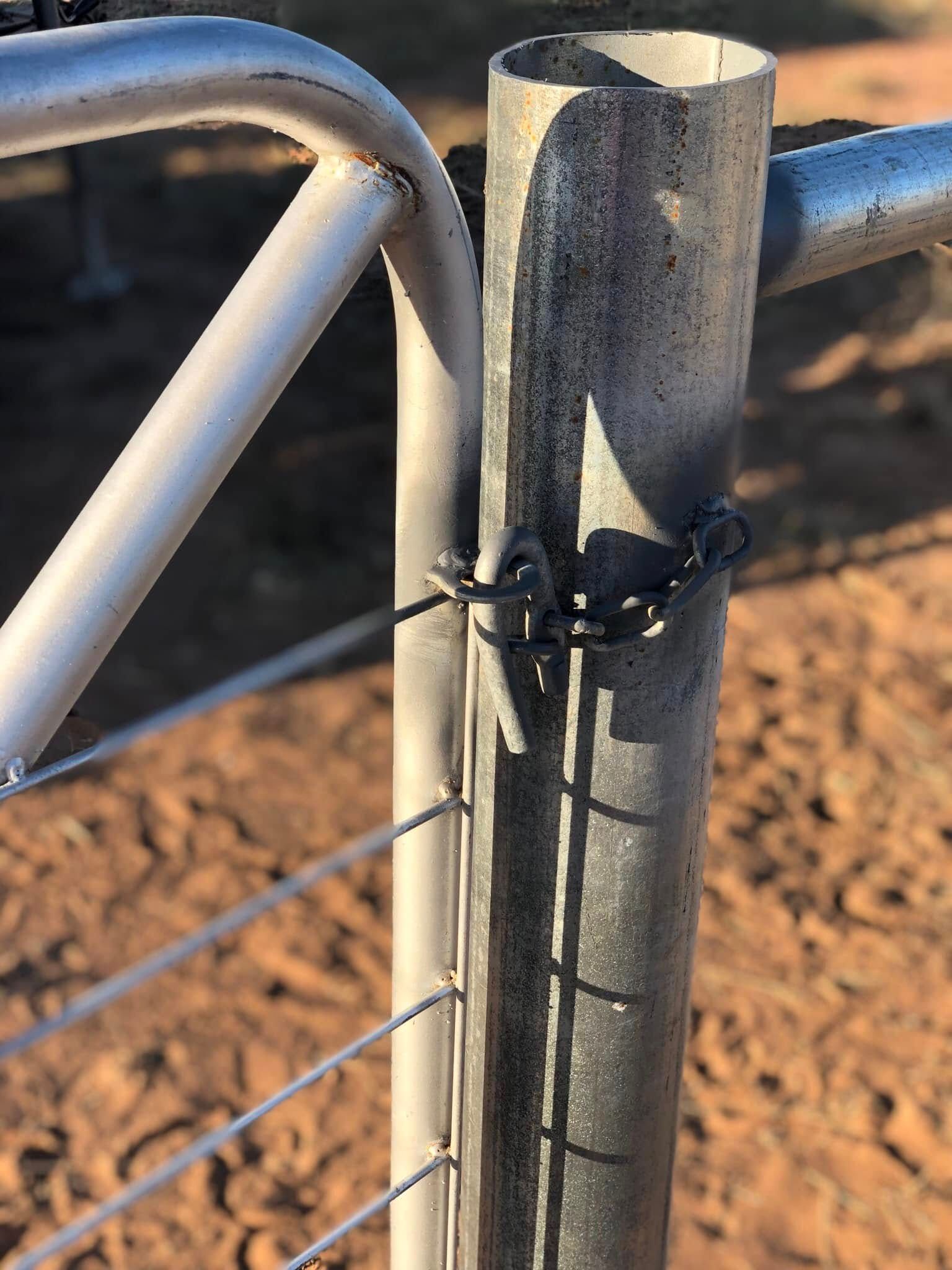 A close up of a metal fence with a chain around it.