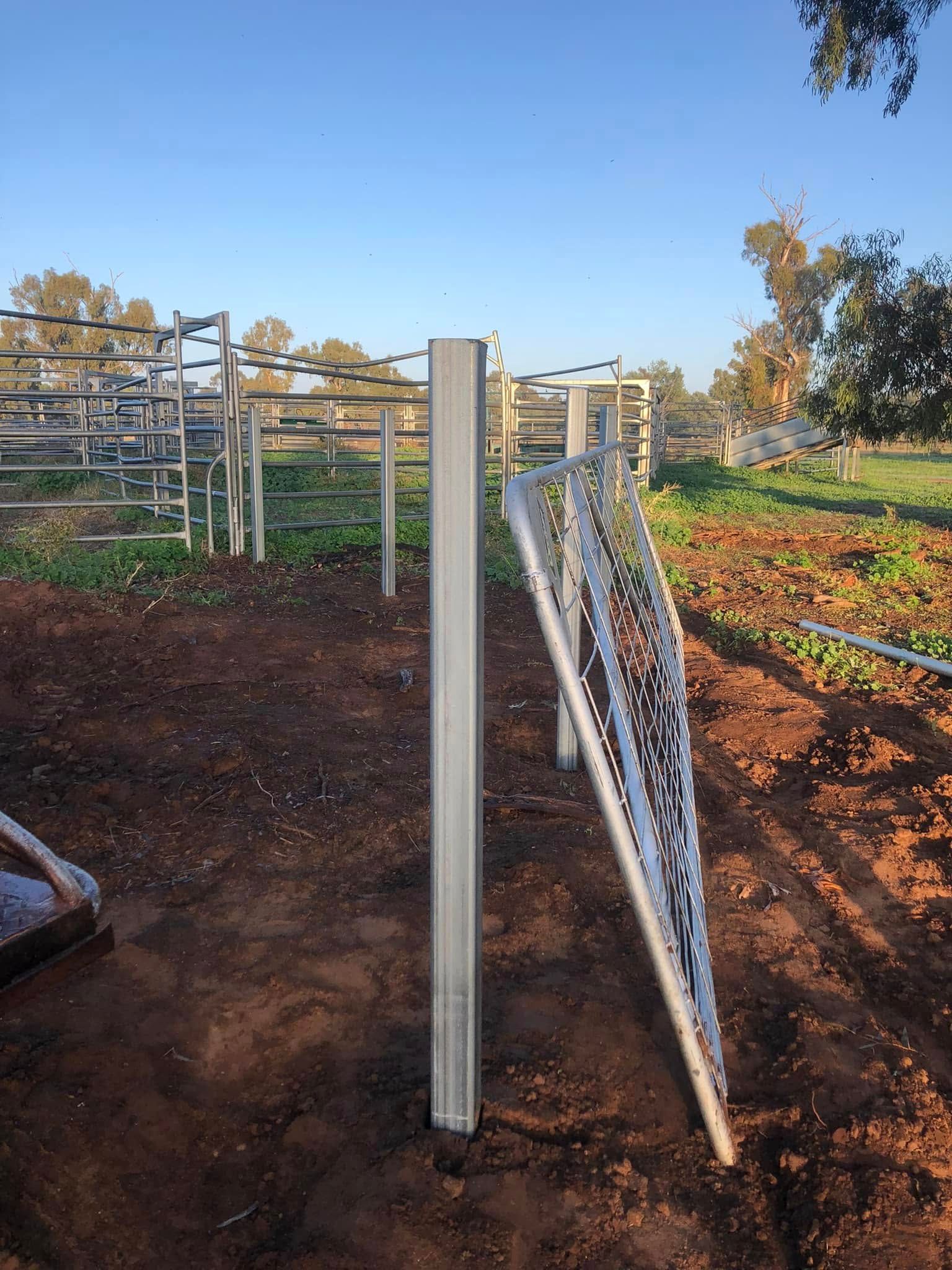 A chain link fence is being built in a field.
