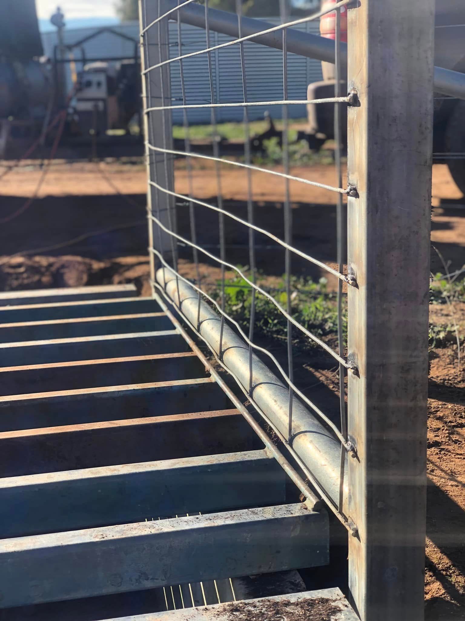 A close up of a metal fence with stairs in the background