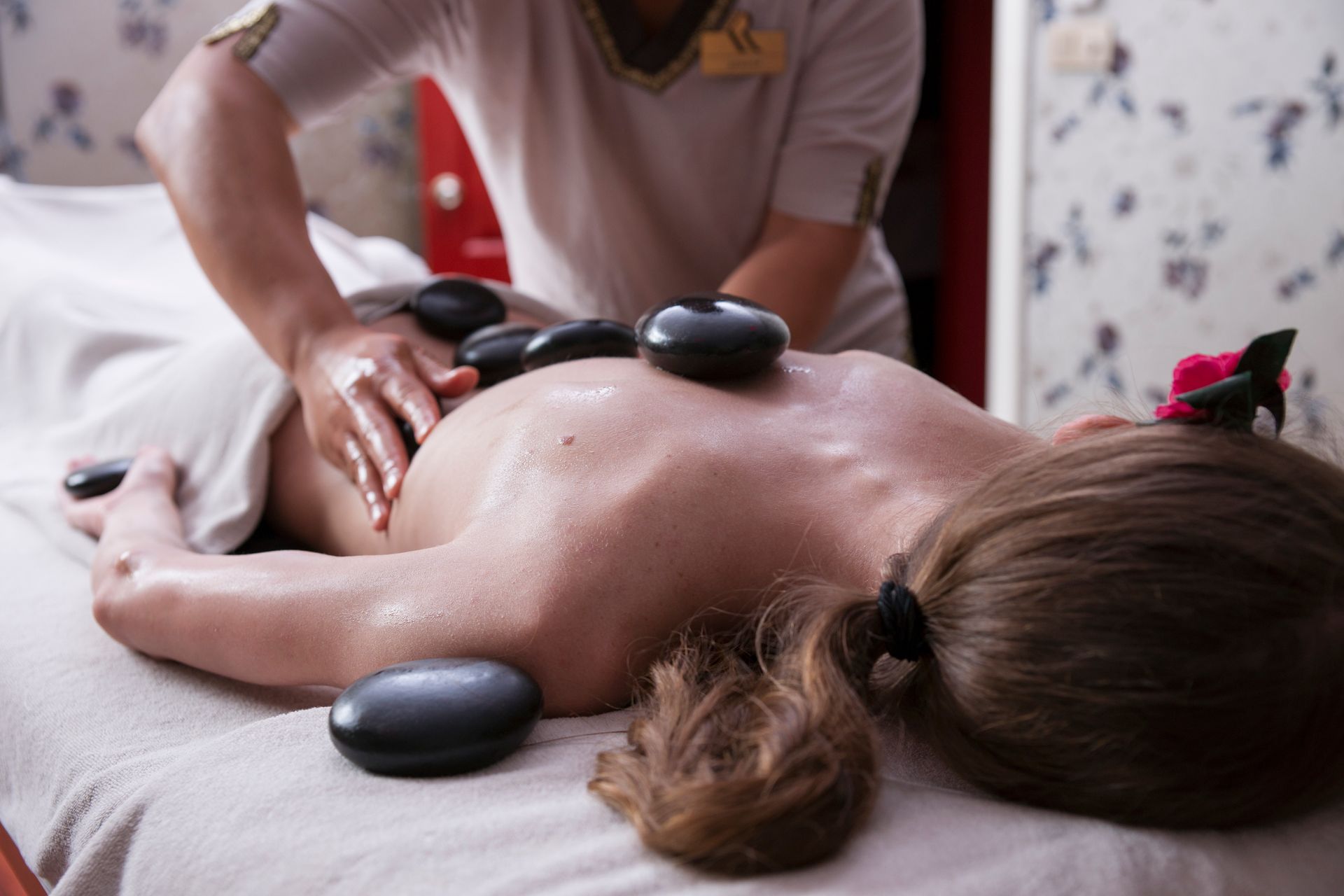 a woman is getting a hot stone massage at a spa .
