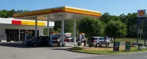 A gas station with cars parked in front of it.