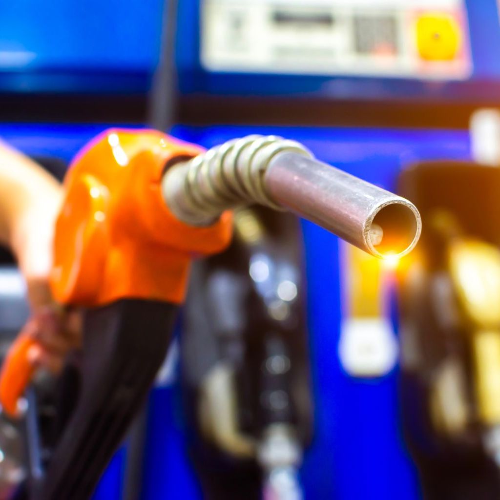 A person is pumping gas into a car at a gas station.