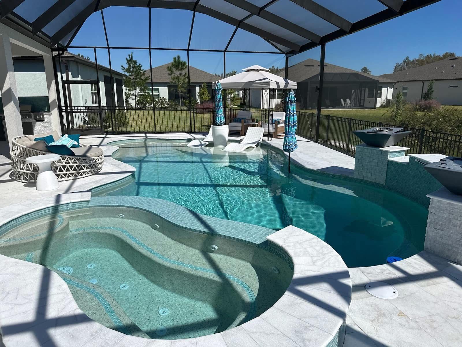 Backyard pool with a covered patio, lounge chairs, and a shallow sun shelf with built-in seats.