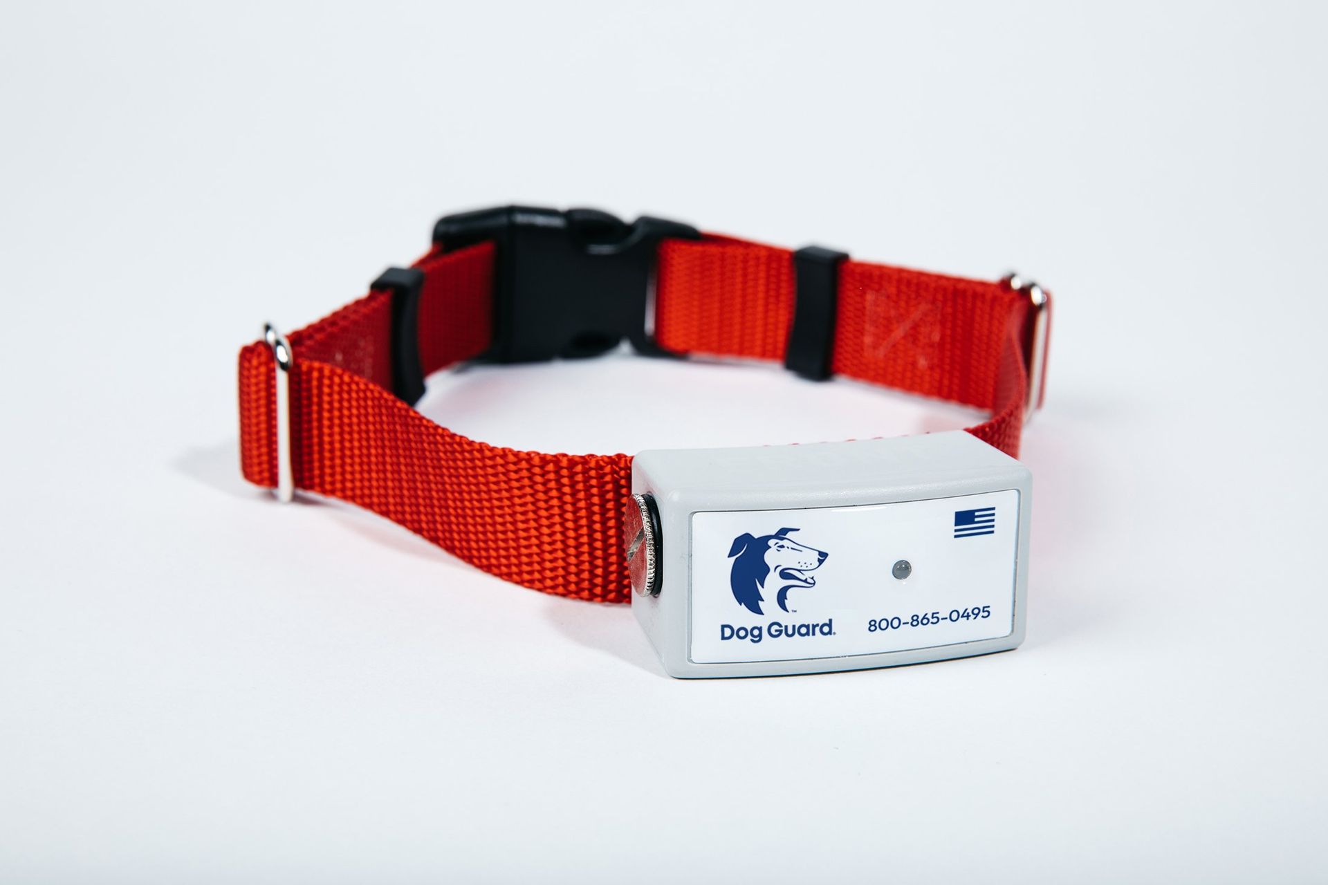 A red dog collar with a gray rectangular electronic receiver featuring the Dog Guard logo and a small US flag.