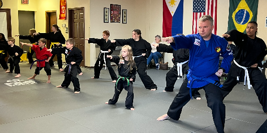 A group of people are practicing martial arts in a gym.