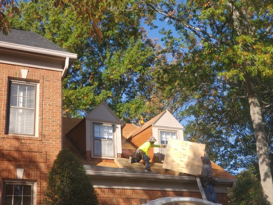 A man is working on the roof of a house