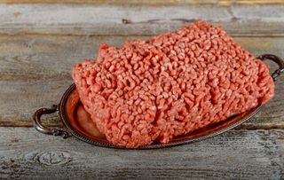 Raw minced ground beef on old wood background.