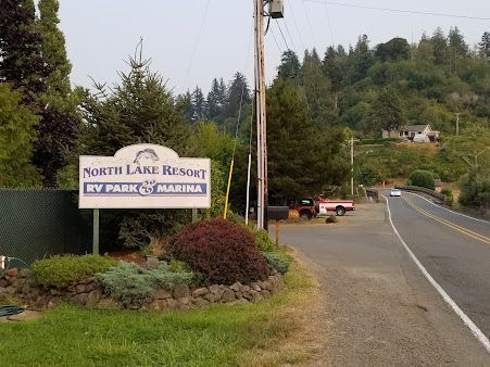 Sign for North Lake Resort RV Park & Marina with road and trees.
