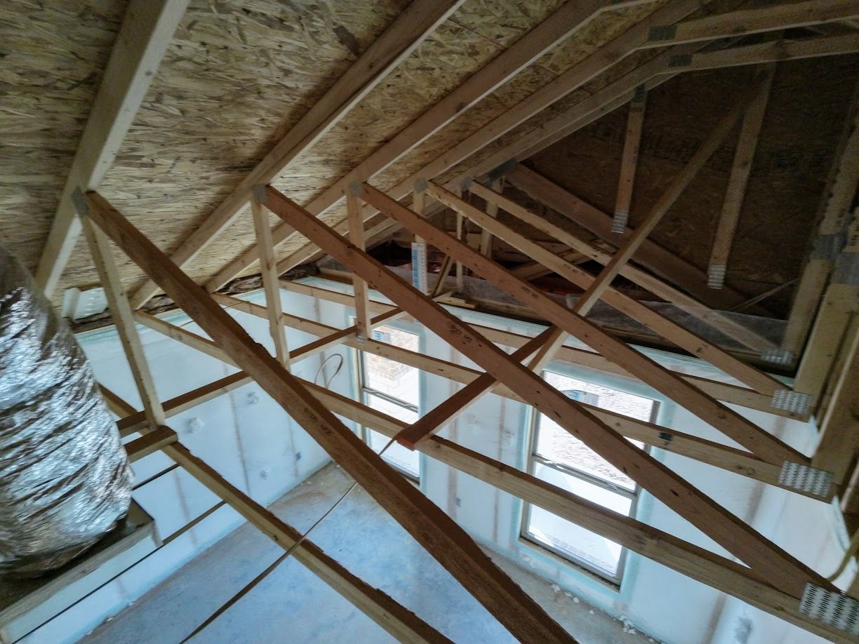 Woman in straw hat smiles, holding wine glass near a lake.