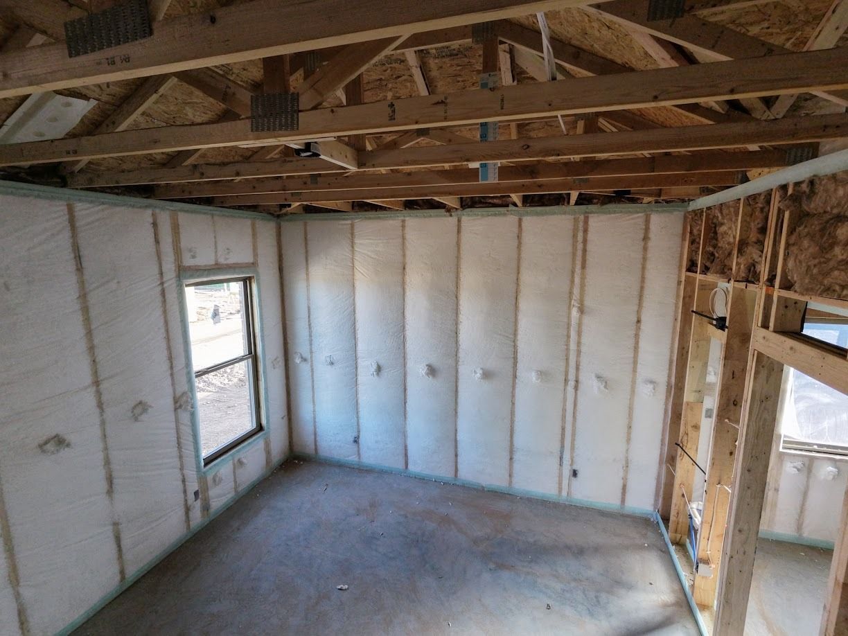Woman in straw hat smiles, holding wine glass near a lake.