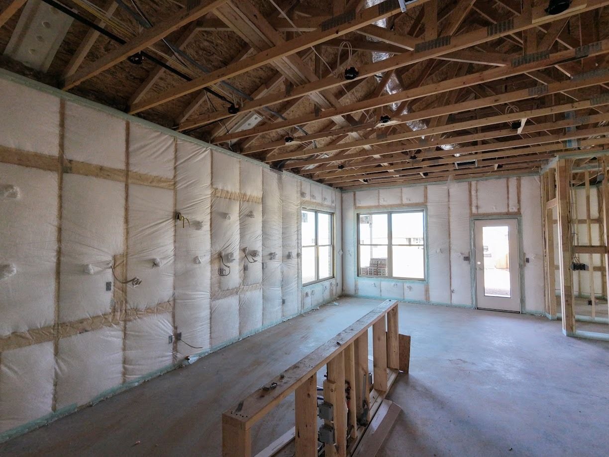 Woman in straw hat smiles, holding wine glass near a lake.