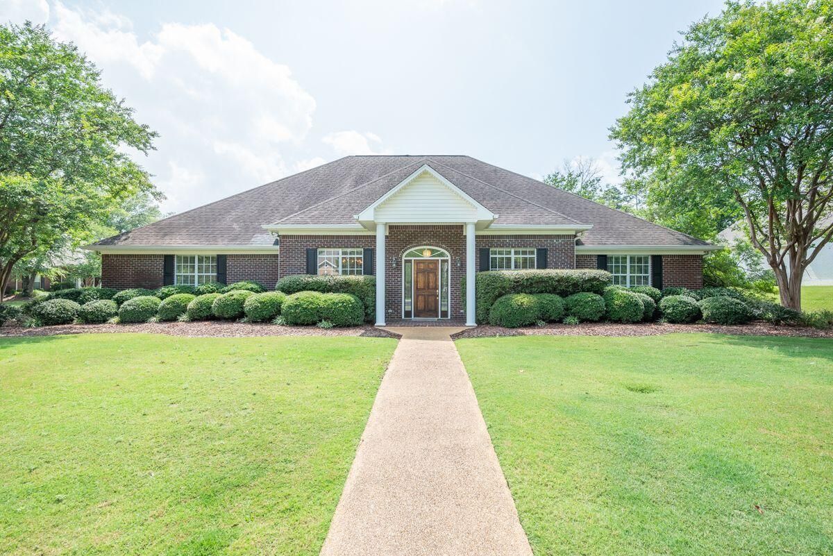 a brick house with a walkway leading to the front door