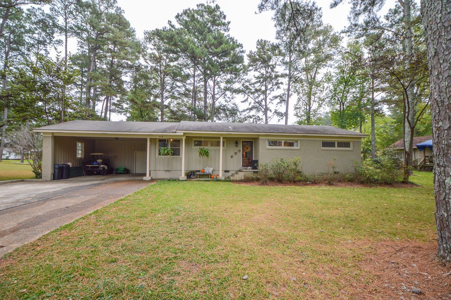 the front of a house with a porch and a garage