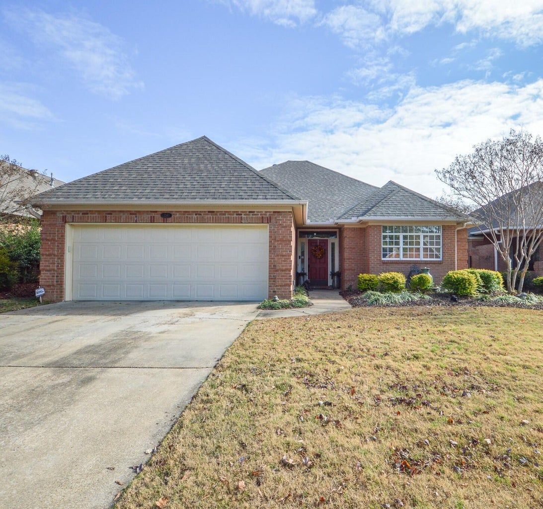the front of a brick house with a white garage door