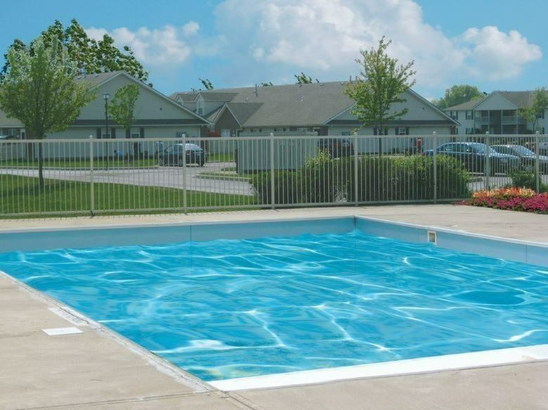 A large swimming pool with a fence around it at Aspire Apartment Homes.
