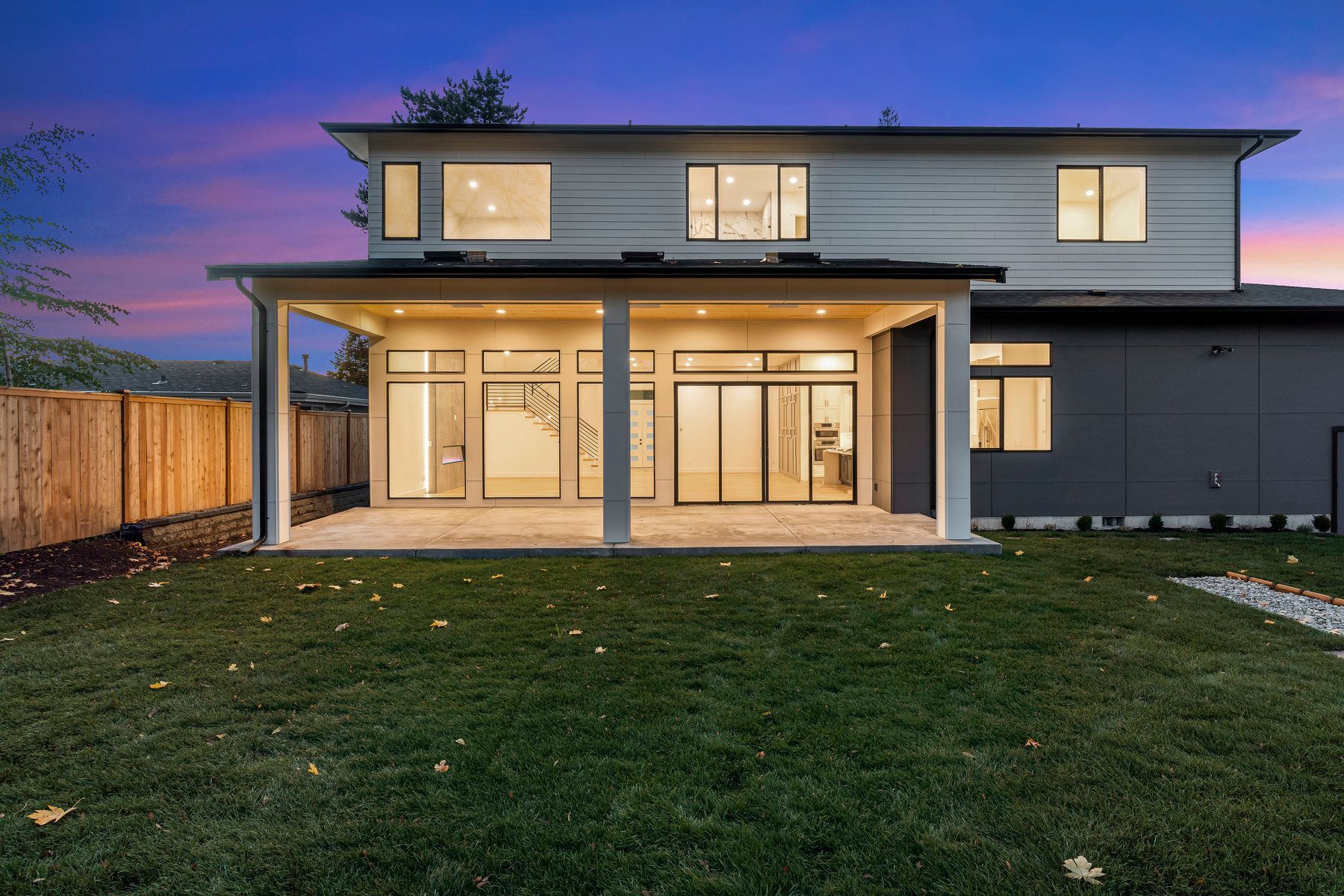 The back of a house with a large covered patio and a lot of windows.