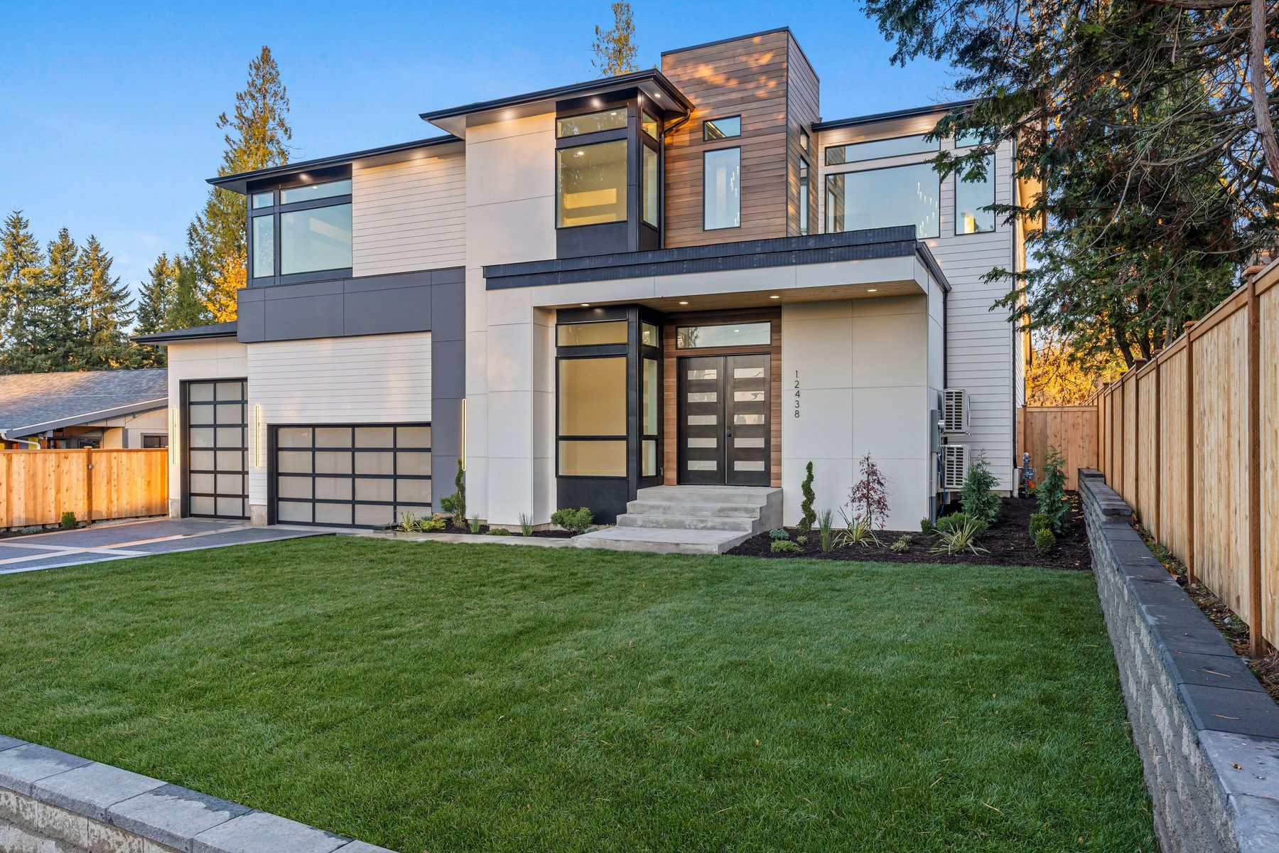 A large modern house with a large lawn in front of it.