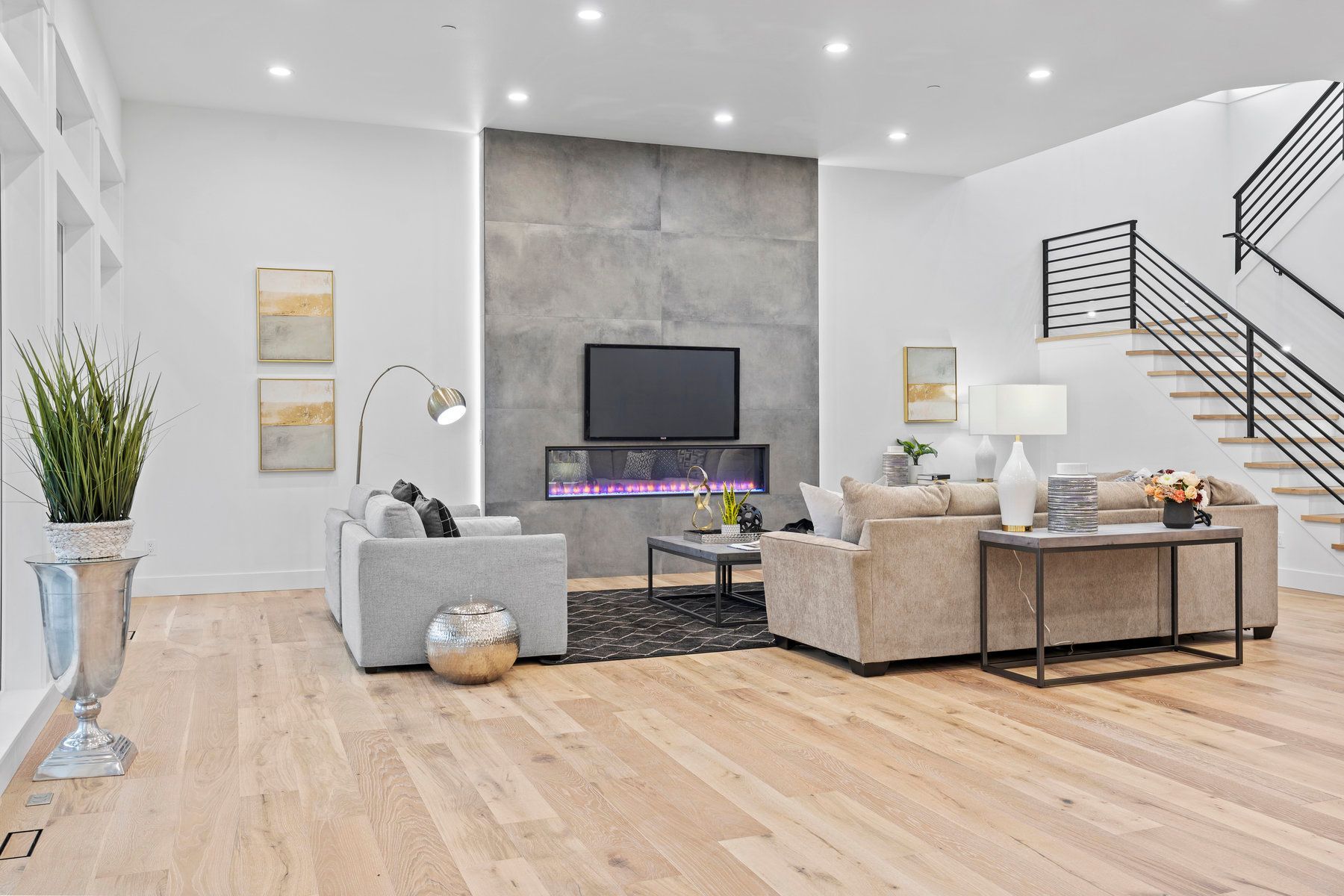 It is a living room with hardwood floors and a fireplace.