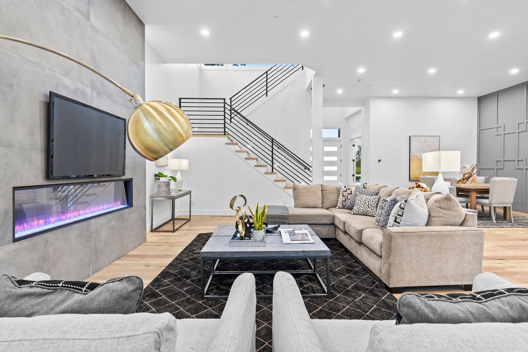 A living room with a couch , chairs , coffee table and television.
