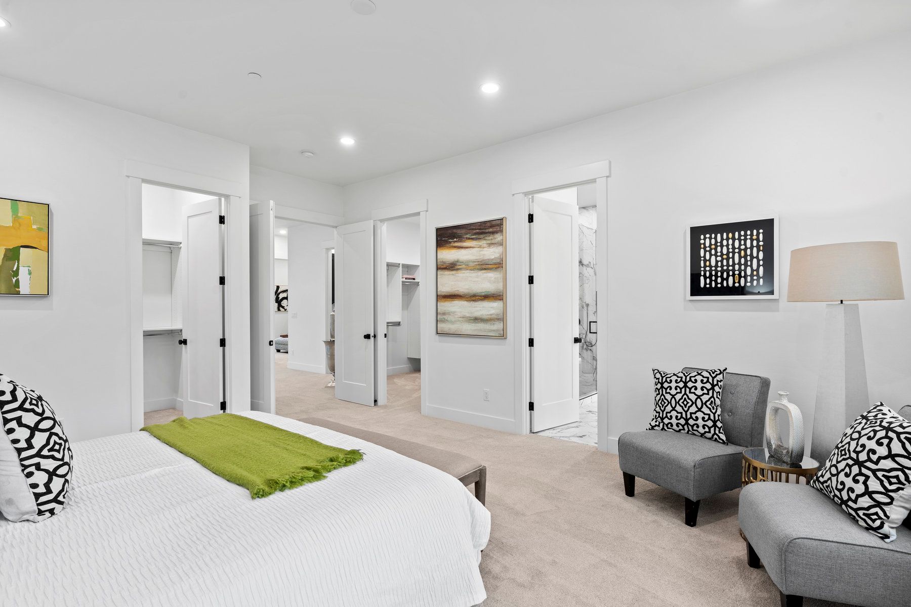 A bedroom with a bed , chairs and a lamp.