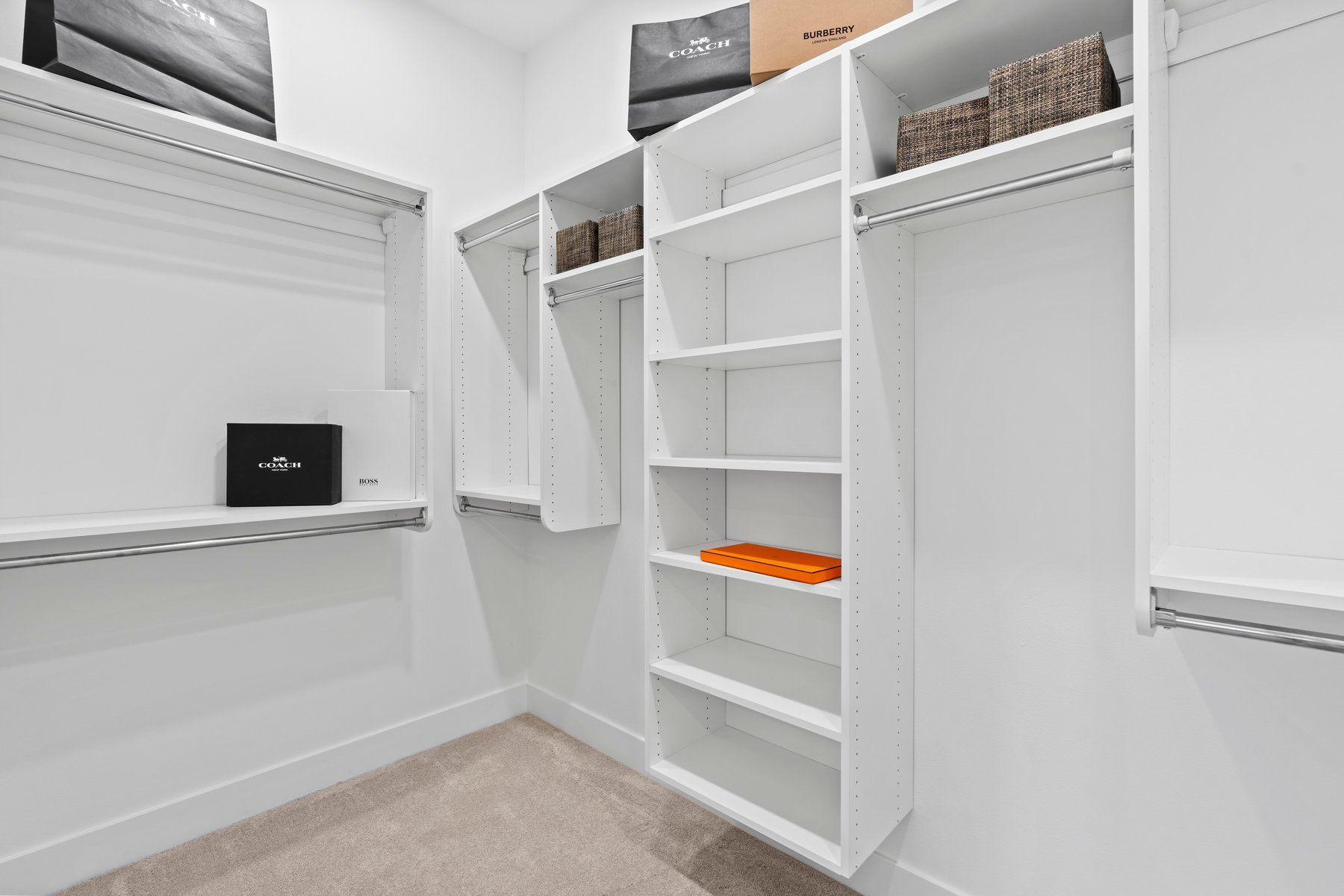 A walk in closet with lots of shelves and clothes on them.