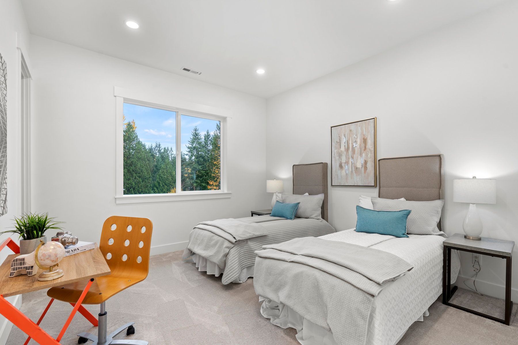 A bedroom with two beds , a desk and a window.