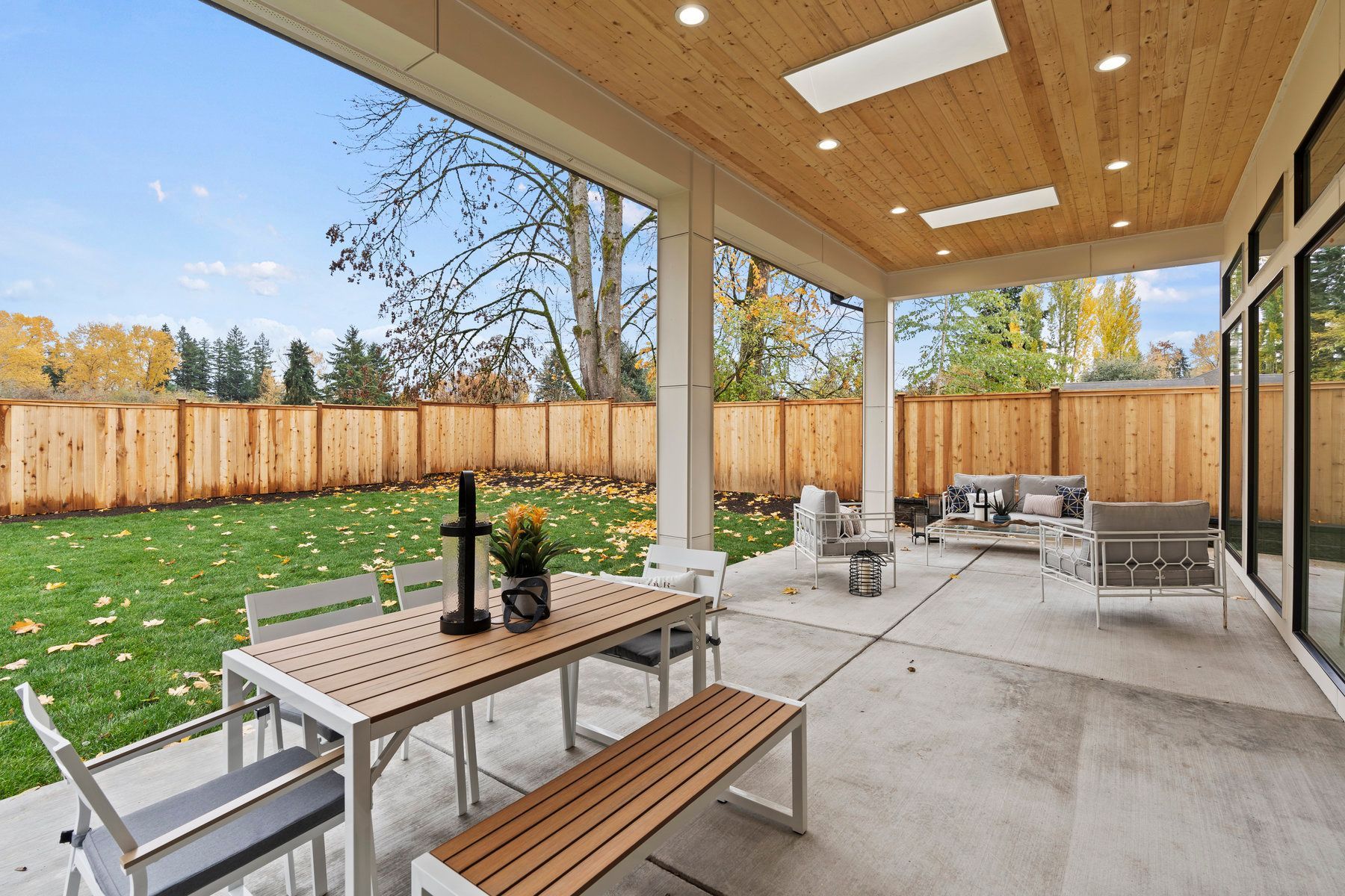 There is a patio with a table and chairs and a bench.