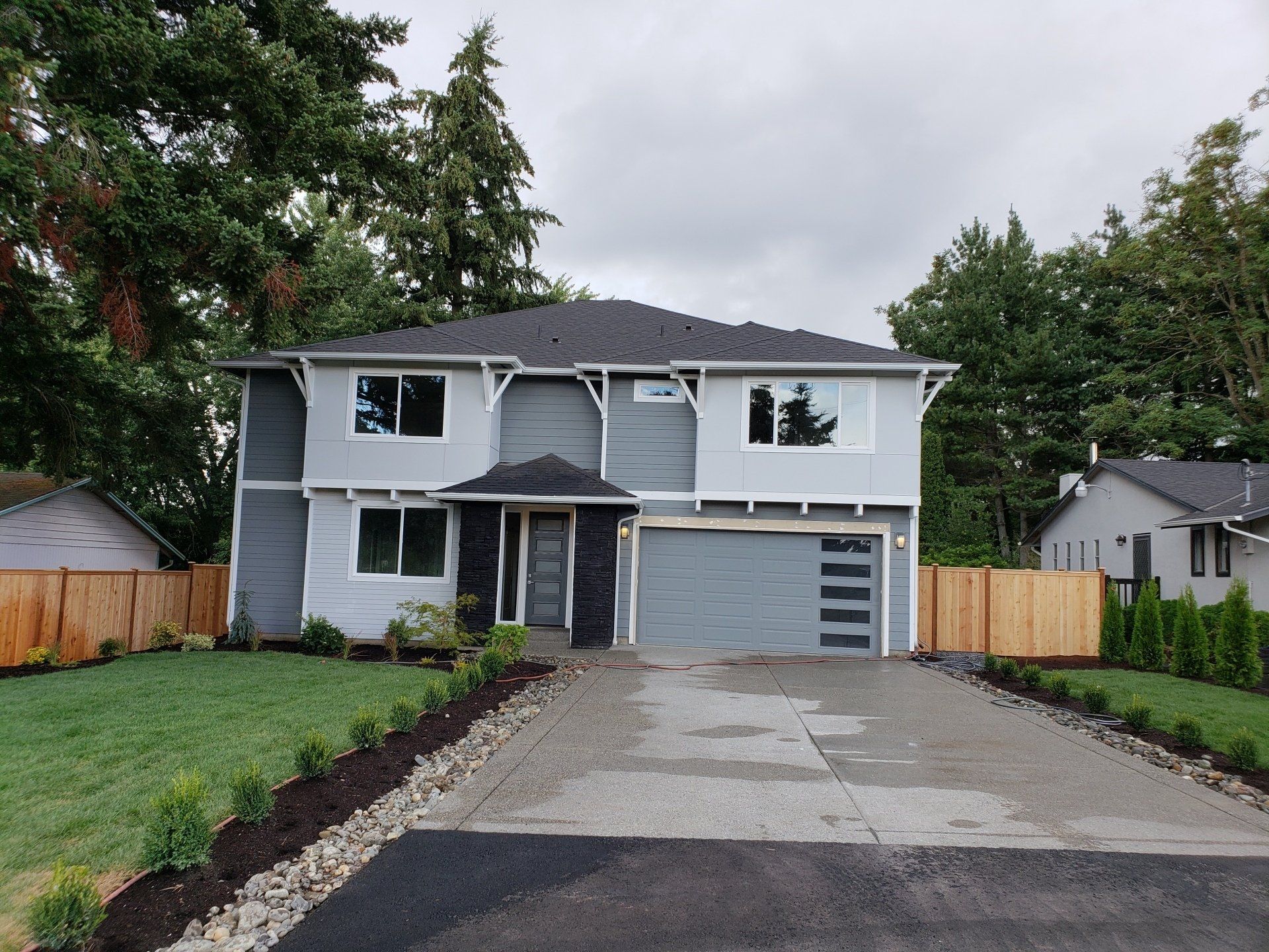 A house with a driveway and a fence in front of it