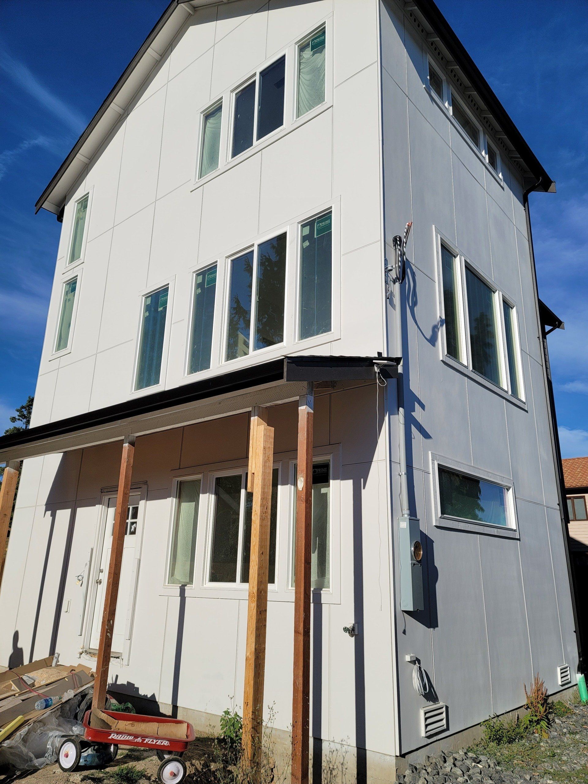 A large white house with a lot of windows is being built.
