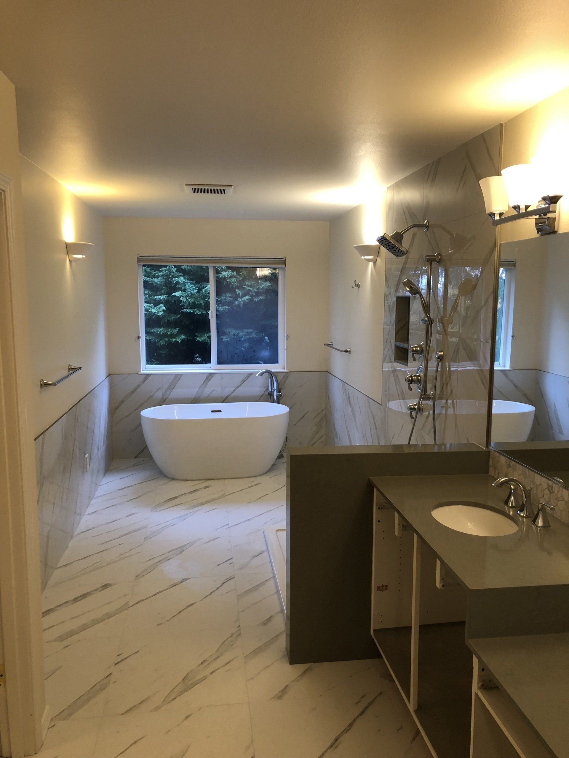 A bathroom with two sinks , a tub and a shower.