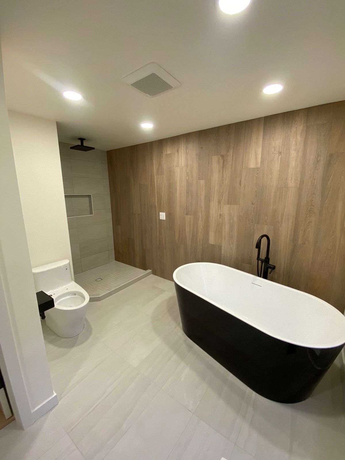 A bathroom with a bathtub , toilet and shower.