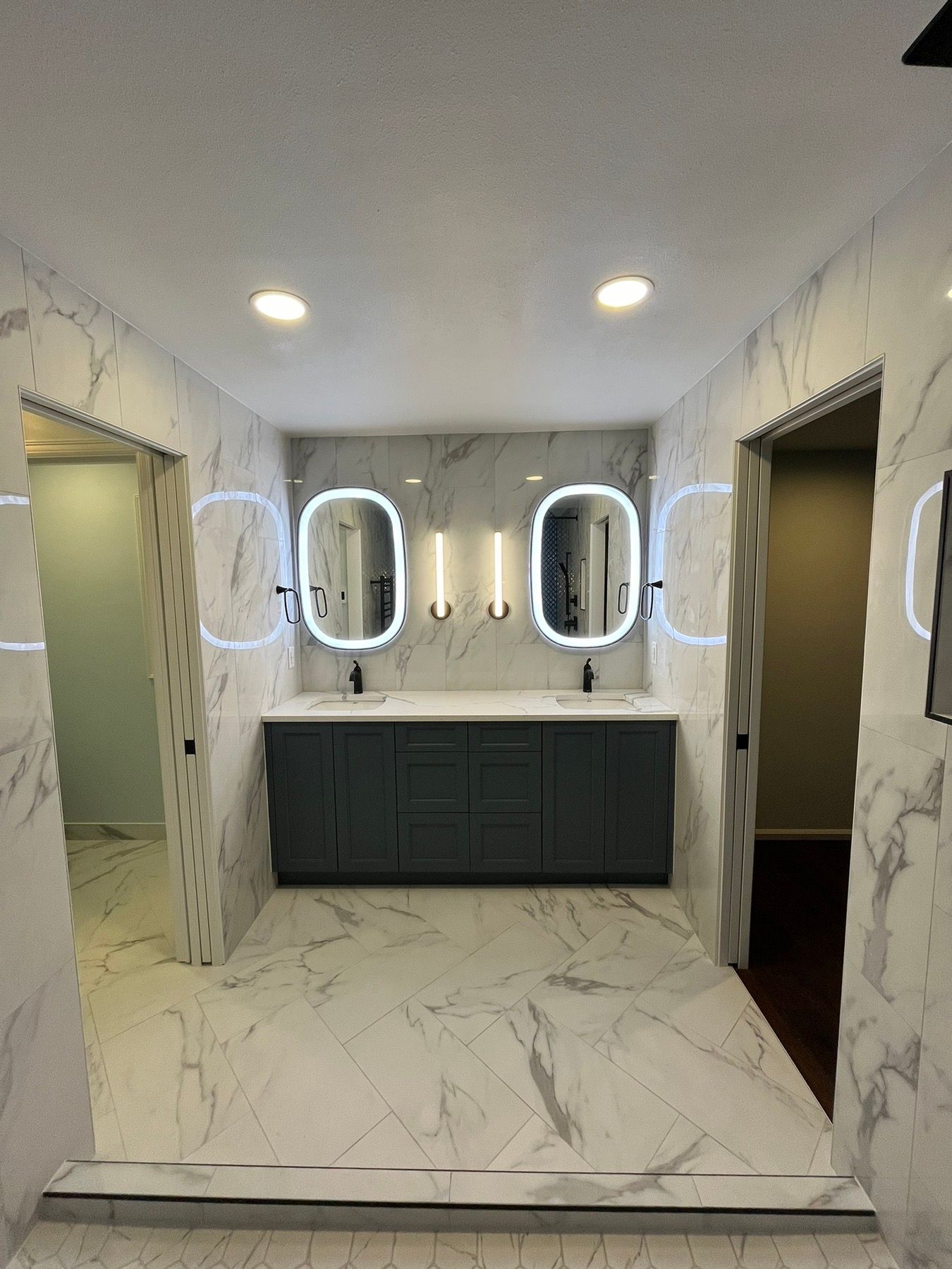 A bathroom with two sinks and two mirrors with neon lights