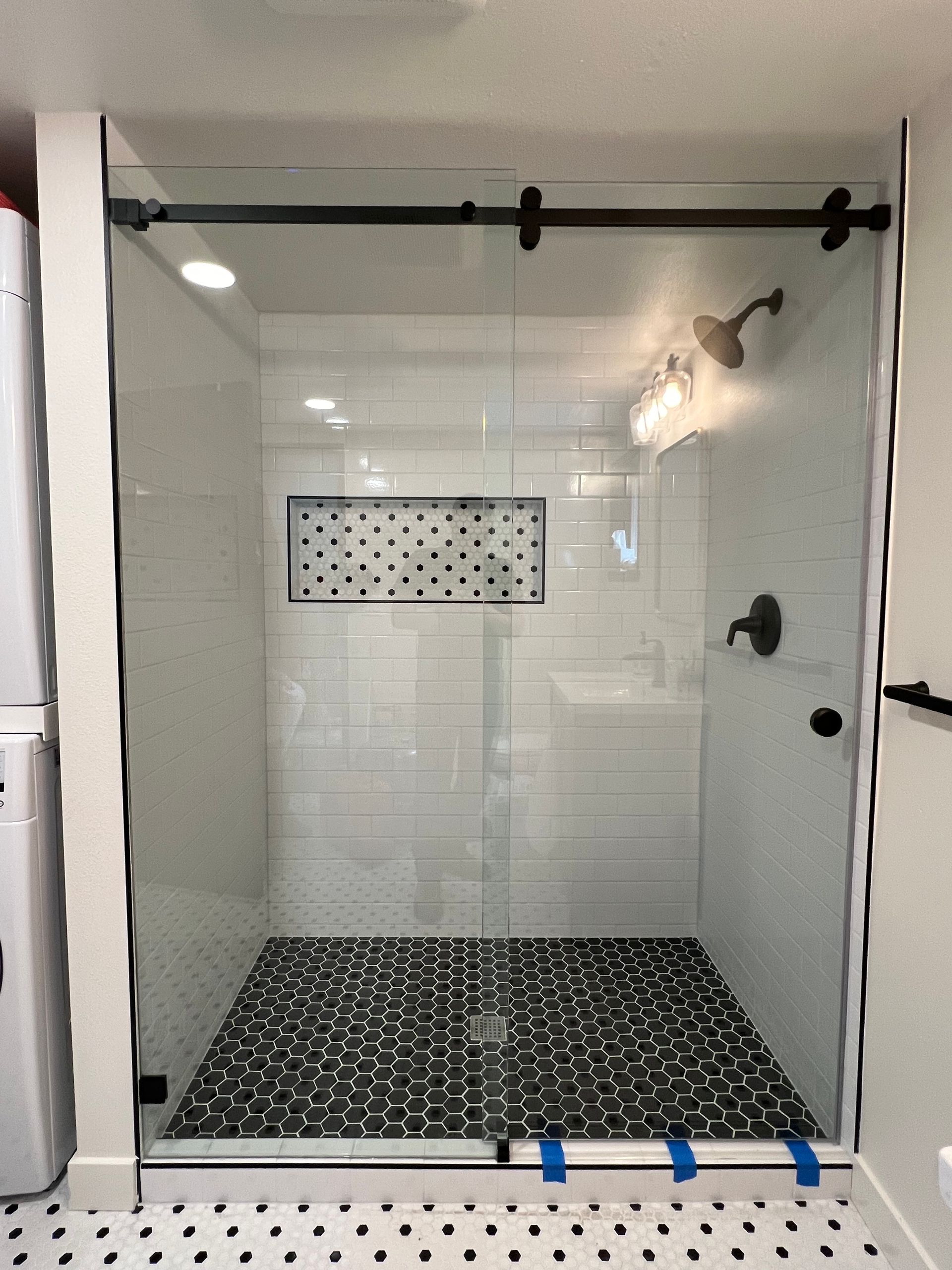 A bathroom with a sliding glass shower door