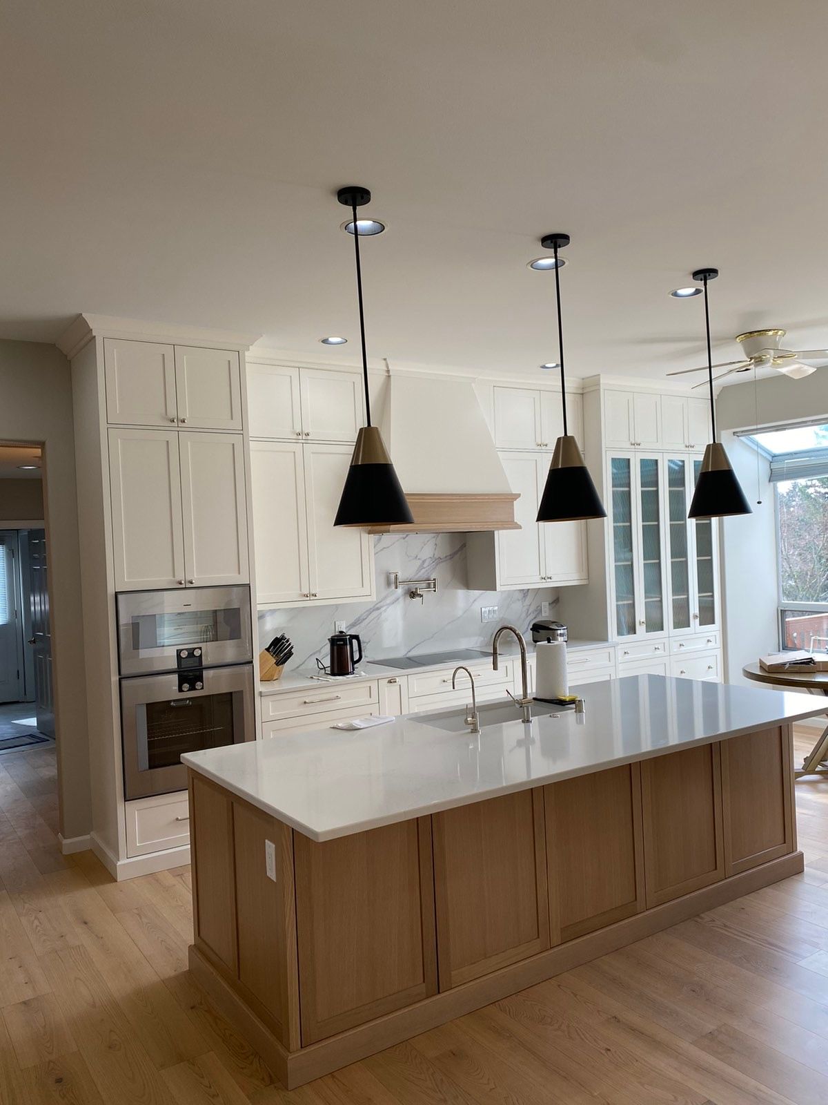 A kitchen with white cabinets and a large island in the middle.