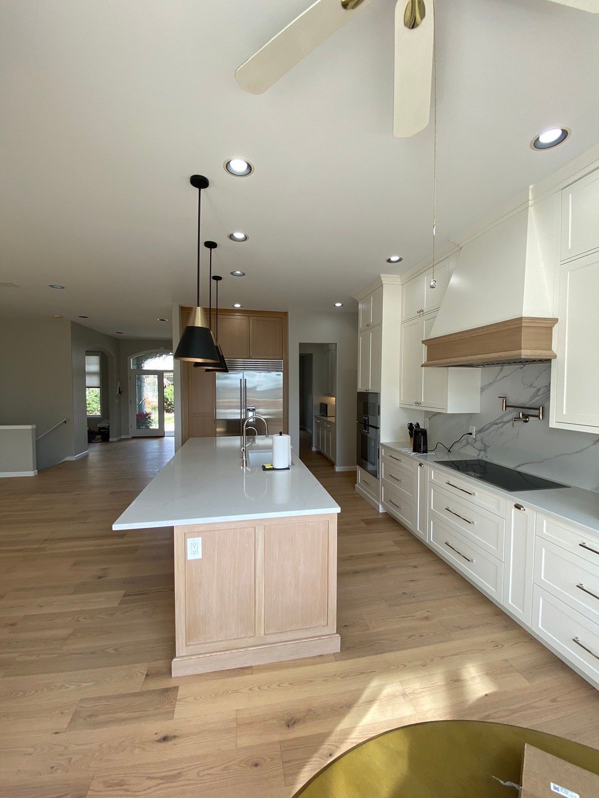 A kitchen with white cabinets and a large island in the middle.