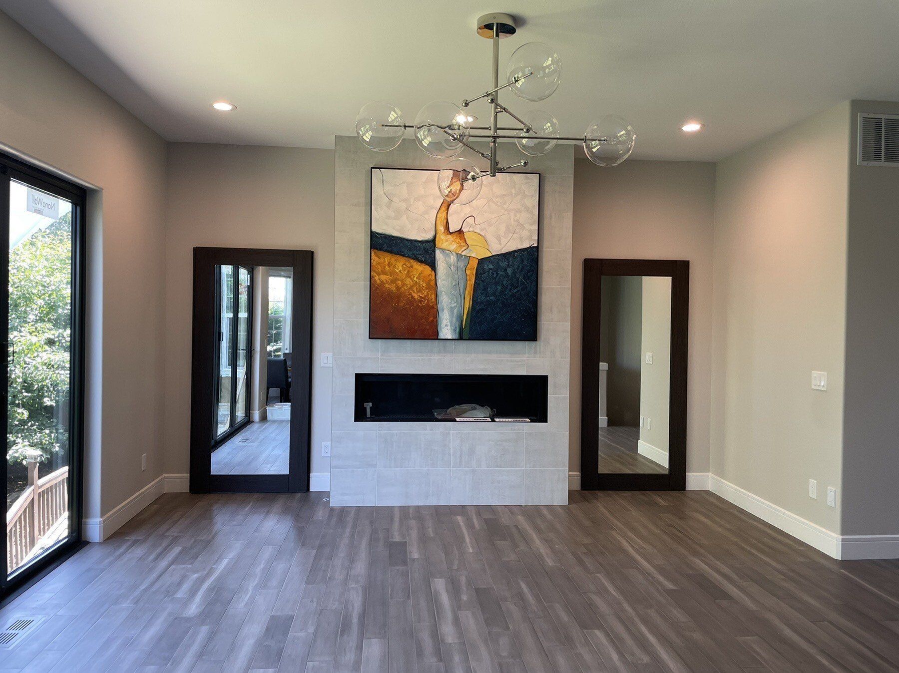 A living room with a fireplace and a painting on the wall.