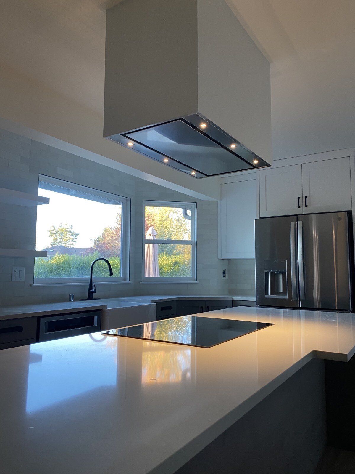 A kitchen with stainless steel appliances and white counter tops