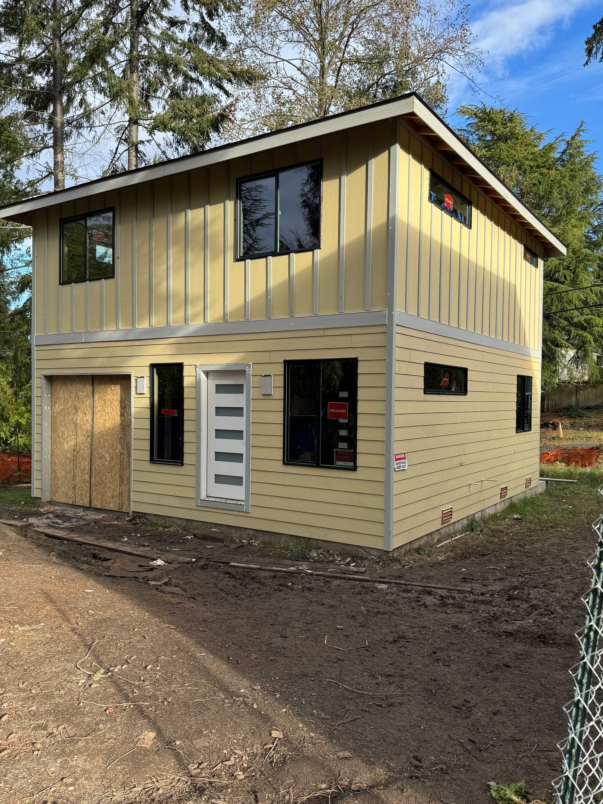 A small house is being built in the middle of a dirt field.